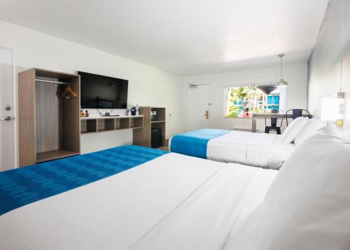 a hotel room with two beds and a television at Coco Key Hotel & Water Park Resort in Orlando