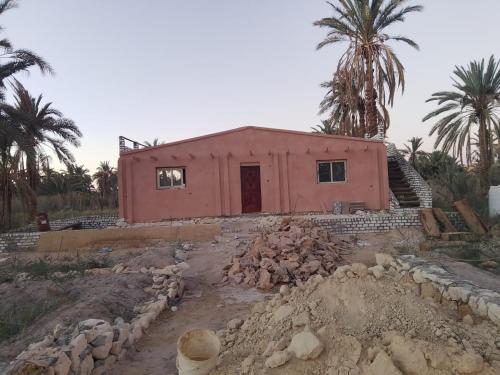 a house is under construction with rocks around it at Villa Rumi Siwa in Damshīt