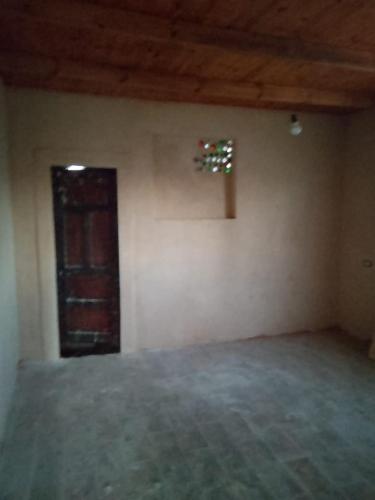 an empty room with a door and a window at Villa Rumi Siwa in Damshīt