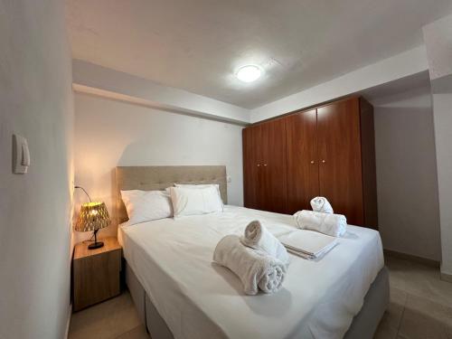 a bedroom with a large white bed with towels on it at Evdilos blue serenity by BRP-PROPERTIES in Evdilos