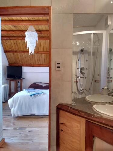 a bathroom with two sinks and a bed in a room at Posada la Piedra in Constitución