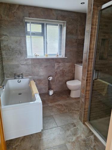 a bathroom with a white tub and a toilet at Room with a View in Glastonbury