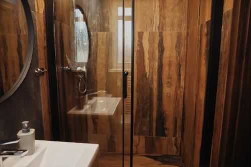 a bathroom with a glass shower with a sink at Penzion Kastiel in Veľký Krtíš