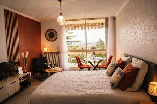 a bedroom with a bed and a table and a window at Charmant Studio, 2 personnes, 25 minutes du Zoo de Beauval in Montrichard