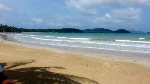 a person standing on a beach with the ocean at Happy Days Resort in Ko Mak