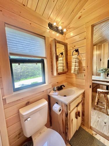 a small bathroom with a toilet and a sink at Cozy Coastal Cabin 5 in Steuben