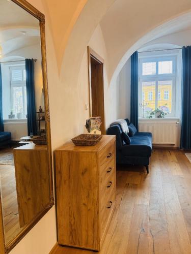 a living room with a mirror and a blue couch at Apartmán CORA in Jaroměř