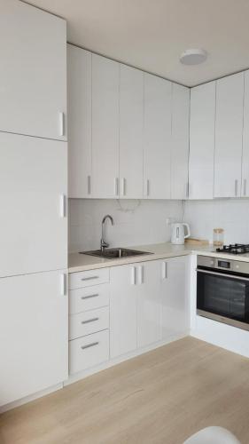 une cuisine blanche avec des armoires blanches et un évier dans l'établissement Sevan lake view, à Tsovagyugh