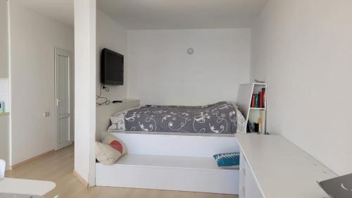 une chambre blanche avec un lit et une télévision dans l'établissement Sevan lake view, à Tsovagyugh