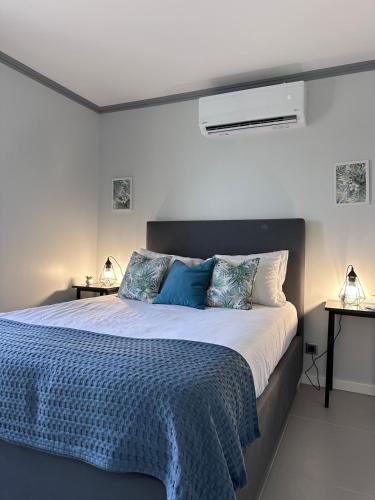 a bedroom with a large bed with blue pillows at Harmonia Guest House in Ponta Delgada