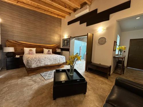 a bedroom with a bed and a living room at Hotel Matea San Isidro in Tonatico