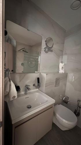 ein Badezimmer mit Waschbecken, Toilette und Spiegel in der Unterkunft Marigold Tripoli hotel فندق ماري قولد in Tripoli