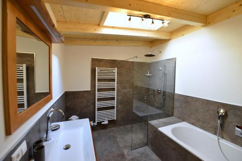 a bathroom with a tub and a shower and a sink at Ferienhaus Strohschneider in Hermagor