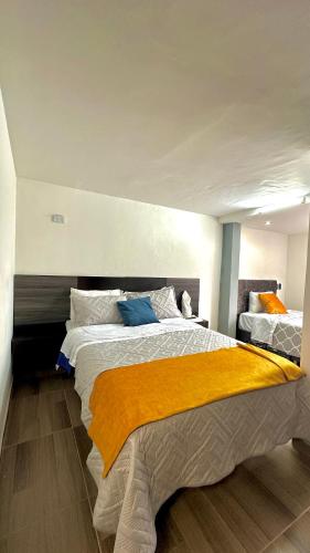 a bedroom with a large bed with a yellow blanket at LourdesInn65 in Bogotá