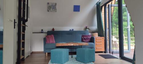 a living room with a blue couch and a table at Bieszczadzkie Asy in Polana