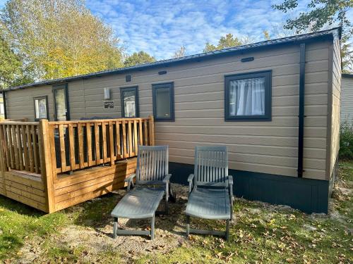 two chairs sitting on the deck of a tiny house at Chalet Jersey in Lauwersoog