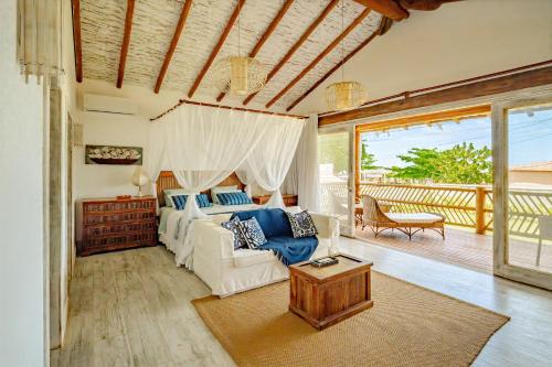 a living room with a white couch and a bed at Casa Mandala Corumbau in Corumbau