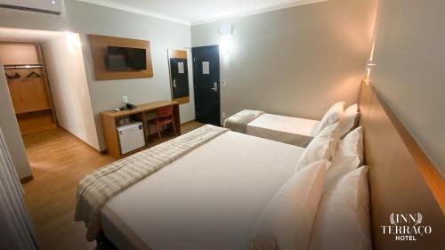a hotel room with a bed and a television at INN TERRAÇO Hotel in Mirandópolis