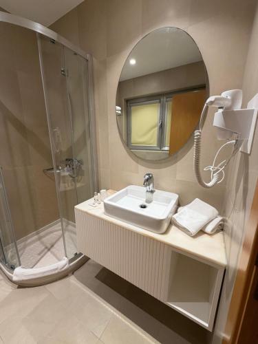 a bathroom with a sink and a shower with a mirror at Hotel Albergaria Borges in Chaves