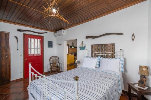 a bedroom with a bed and a red door at Dust in The Wind Sunrise in Triovasálos