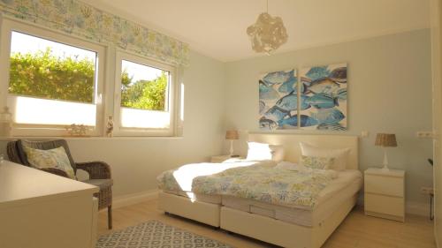 a bedroom with a bed and two windows at Haus Jonas in Tinnum