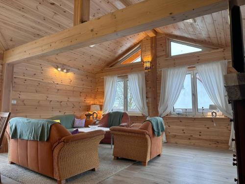 a living room with two couches and two windows at Ferienhaus 4 Elemente in Selchow mit tollem Garten in Selchow