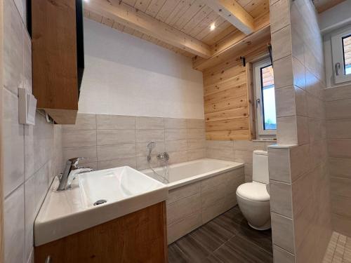 a bathroom with a tub and a toilet and a sink at Ferienhaus 4 Elemente in Selchow mit tollem Garten in Selchow