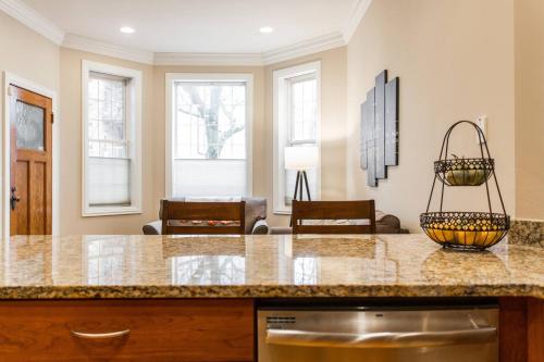 a kitchen with a counter top and a living room at The Wrigleyville VIP-200 Steps from Wrigley Field in Chicago