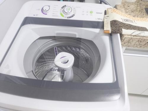 a washing machine with its door open on a counter at Juhh Bella Condomínio in Botucatu