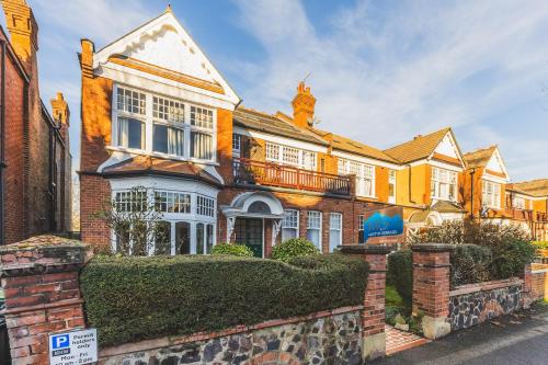 a large brick house with a fence in front of it at Beautiful one bed garden flat in Muswell hill in London