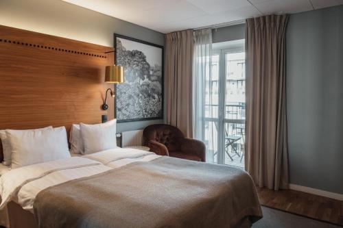 a hotel room with a large bed and a window at Home Hotel Temperance in Malmö