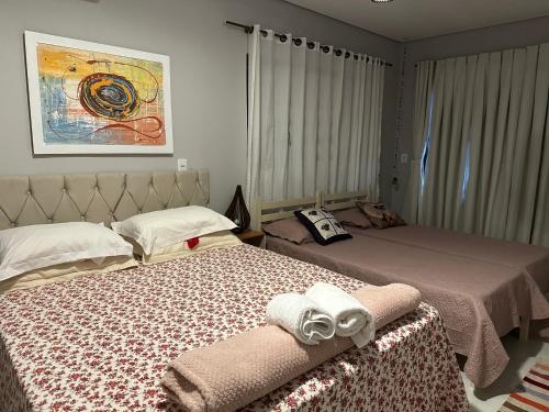 a bedroom with two beds with towels on them at Pousada Luar in Chapada dos Guimarães