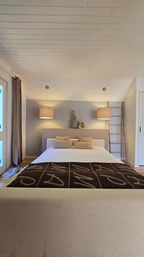 a bedroom with a large white bed with two lamps at Ferreirinha Valley in Vieira do Minho