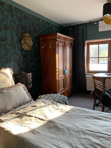 a bedroom with a bed and a cabinet and a table at Gästehaus Auszeit in Riesa