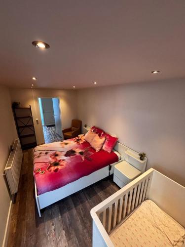 a bedroom with a bed with a red blanket at The perfect spot in Akersloot