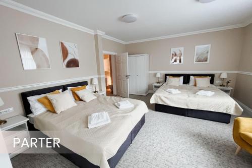 two beds in a hotel room with two beds at Villa Adele in Polanica-Zdrój