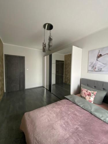 a bedroom with a large bed with a pink blanket at CentralPark in Kostrzyn nad Odrą