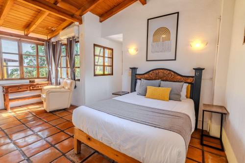 a bedroom with a bed and a chair in a room at Casa Hidalgo Hideaway in Chapala