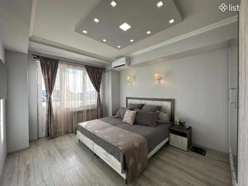 a bedroom with a bed and a large window at Apartment Zaqyan street in Yerevan