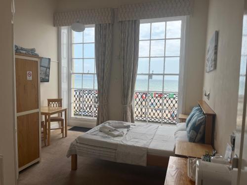 a bedroom with a bed and a large window at The Edenhurst Guesthouse in Weymouth