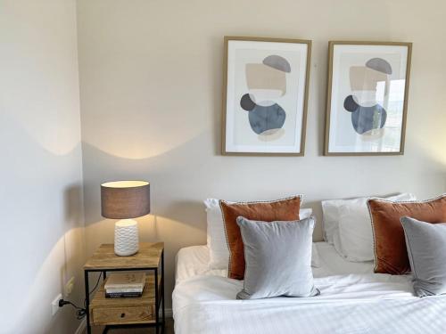 a bedroom with a white bed with two pictures on the wall at Glens Haven with Lakeviews and Outdoor Firepit in Wagga Wagga