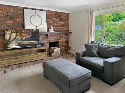a living room with a couch and a tv at Glens Haven with Lakeviews and Outdoor Firepit in Wagga Wagga