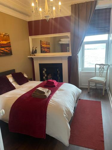 a bedroom with a large bed and a fireplace at An Cuilidh in Port Bannatyne