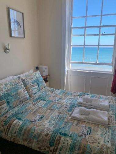 a bed with towels on it in a bedroom at The Edenhurst Guesthouse in Weymouth