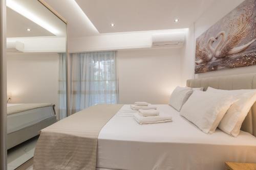 a bedroom with a bed with two towels on it at varkiza luxury 2BD apartment in Varkiza