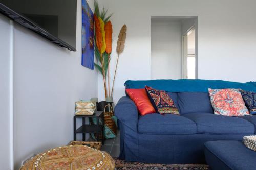 a blue couch with colorful pillows in a living room at 42 Coogee Beach Marina 3BR Haven near Omeo Wreck in Coogee