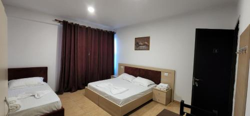 a bedroom with two beds and a window at Hotel kleo Airport tirana in Tirana