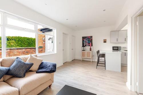 a living room with a couch and a kitchen at Stylish 2 Bedroom Apartment in Liverpool - Gateacre Village - Free Parking in Liverpool
