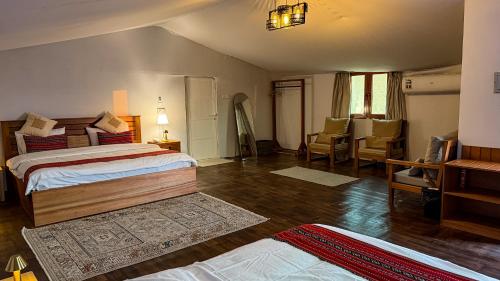 a bedroom with two beds and a living room at Remal Desert Retreat Bidiyah in Badīyah