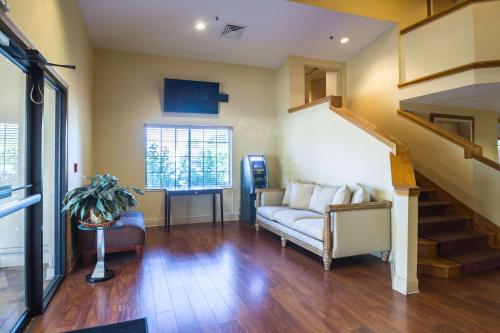 a living room with a couch and a staircase at Motel 6-Indianapolis, IN - Airport in Indianapolis